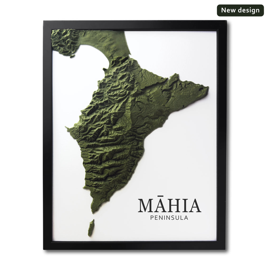 Framed wall art featuring a 3D relief map of the Máhia Peninsula in olive green tones on a white background, with the text 'MÁHIA PENINSULA' at the bottom and a small 'New design' badge in the top right corner.